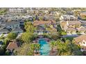 Aerial view of a stunning community pool with palm trees and nearby shopping at 4038 Hunters Park Ln, Orlando, FL 32837