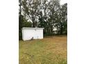 Spacious backyard with a small shed and a green lawn surrounded by mature trees at 4206 Clarinda St, Orlando, FL 32811