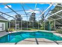 Screen enclosed pool, with blue water and view of backyard at 4537 Woodlands Village Dr, Orlando, FL 32835