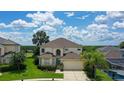 Beautiful two-story home with lush landscaping, a spacious driveway, and a charming blue front door at 523 Higher Combe Dr, Davenport, FL 33897