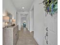 Bright entryway featuring neutral tile flooring, a decorative mirror, and a hall table at 585 Mosaic Blvd, Daytona Beach, FL 32124