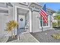 Close up of a charming front entrance with an American flag and welcoming decor at 585 Mosaic Blvd, Daytona Beach, FL 32124