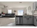 Open floor plan showcases kitchen with stainless appliances flowing into the living room with a large window at 650 Peyton Brooke Way, Winter Haven, FL 33881