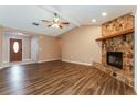 Inviting living room with vaulted ceiling, stone fireplace, and stylish wood-look floors at 7215 Scenic Pl, Lakeland, FL 33810