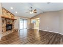 Bright living room boasts wood floors, stone fireplace, and sliding door access to outdoor area at 7215 Scenic Pl, Lakeland, FL 33810