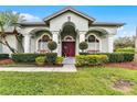 Charming home showcasing a lush green lawn and a welcoming front entrance with unique door at 739 Spring Island Way, Orlando, FL 32828