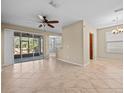 Spacious living room featuring tile flooring, a ceiling fan, and sliding glass doors to the lanai at 8323 Bella Vida Cir, Davenport, FL 33896