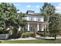 Inviting two-story home with white siding, shutters, manicured garden, and classic architectural details at 909 E Central Blvd, Orlando, FL 32801