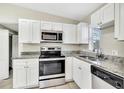 Updated kitchen featuring stainless steel appliances, granite countertops, and white cabinets at 913 Ferndell Rd, Orlando, FL 32808