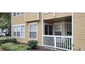Tan condo exterior with a small balcony, white trim, and green landscaping at 1029 S Hiawassee Rd # 2414, Orlando, FL 32835