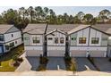 Aerial view of townhomes with paver driveways, garages, modern design and tree-lined street at 10364 Ebb Tide Ln, Orlando, FL 32821