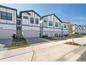 Street-level view of modern townhomes showing individual driveways with paver accents and well-maintained landscaping at 10364 Ebb Tide Ln, Orlando, FL 32821