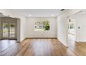 Bright living room with neutral walls, wood-look flooring, window, and open floorplan with access to other rooms at 1607 31St Nw St, Winter Haven, FL 33881