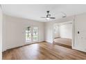 Bright living room featuring wood-look flooring, ceiling fan, and French doors leading to the yard at 1607 31St Nw St, Winter Haven, FL 33881