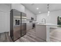 Modern kitchen with stainless steel appliances, island, and gray cabinets at 16224 Sw 55Th Court Rd, Ocala, FL 34473