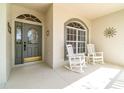 Inviting front porch featuring a decorative glass front door and two rocking chairs, perfect for enjoying the outdoors at 3432 Capland Ave, Clermont, FL 34711