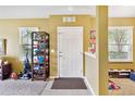 Bright entryway with white door, tiled floor, and view into adjacent carpeted living space at 3528 Seneca Club Loop # 103 - C, Orlando, FL 32808