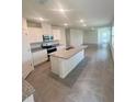 Open-concept kitchen featuring a granite island, stainless steel appliances, and tile floors at 3641 Marlberry Way, Sanford, FL 32773