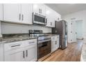 Bright kitchen features stainless steel appliances, white cabinetry, and granite countertops at 411 St Johns Ln, Kissimmee, FL 34759