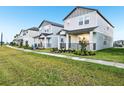 Street view of modern gray homes with manicured lawns in a new development at 4673 Cross Prairie Pkwy, St Cloud, FL 34772
