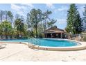 Community pool with clear blue water, surrounding greenery, and lounge chairs at 4828 Pebble Beach Dr # A, Orlando, FL 32811