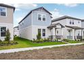 Two-story house featuring light blue siding, a covered porch, and a landscaped front yard at 5093 Railroad Vine Aly, Winter Garden, FL 34787
