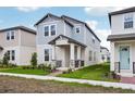 Inviting two-story home with light blue accents, complemented by a neatly landscaped front yard at 5093 Railroad Vine Aly, Winter Garden, FL 34787