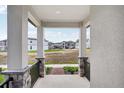 Covered porch with stone pillars and black iron railings, overlooking the community at 5093 Railroad Vine Aly, Winter Garden, FL 34787