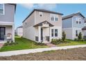 Beautifully designed two-story home featuring a welcoming covered entry and well-manicured lawn at 5099 Railroad Vine Aly, Winter Garden, FL 34787