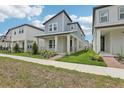 Well-manicured lawn and landscaping lead up to a charming two-story home with a welcoming front porch at 5106 Railroad Vine Aly, Winter Garden, FL 34787