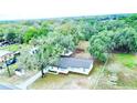Aerial view of the house showcasing mature trees, a newer roof and well-maintained surroundings at 5390 E Hinson Ave, Haines City, FL 33844