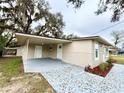 Home featuring large covered parking with ample space for a workshop and beautifully landscaped yard at 5390 E Hinson Ave, Haines City, FL 33844