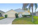 Charming single-story home with a well-manicured lawn and attached two-car garage at 647 Ella Mae Dr, Davenport, FL 33897