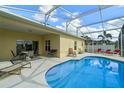 Inviting pool area with covered lanai, lounge chairs, and clear blue water at 647 Ella Mae Dr, Davenport, FL 33897