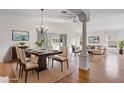 Bright living room features hardwood floors, a modern chandelier, and seamlessly connects to a dining area at 7233 Se 171St Pond Ln, The Villages, FL 32162