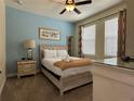 Cozy bedroom features soft blue wall and decorative lamps creating a peaceful retreat at 7668 Wilmington Loop, Kissimmee, FL 34747