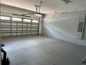 Spacious two car garage with block walls and lighting. Ready for vehicles or extra storage at 7668 Wilmington Loop, Kissimmee, FL 34747