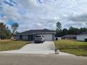 Well-maintained one-story home with a wide driveway, lush lawn, and an attached two-car garage at 12913 Sw 82Nd Avenue Rd, Ocala, FL 34473