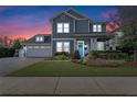 Charming two-story home with blue siding, a manicured lawn, and a welcoming front porch at sunset at 1324 Utah Blvd, Orlando, FL 32803