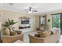 Bright living room featuring neutral furniture, stylish decor, and sliding door access to the outdoors at 1411 Pacific Rd, Poinciana, FL 34759