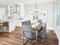 Dining room showcases a modern chandelier, large window, and flows seamlessly into the adjacent kitchen at 16417 Silver Brook Way, Winter Garden, FL 34787