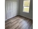 Cozy bedroom featuring wood-look flooring, a window with natural light, and a closet with white paneled doors at 1926 Sw 160Th Sw Pl # 03, Ocala, FL 34470