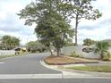 The Atrium community entrance on a wide street, adorned with lush trees and landscaping at 2452 Atrium Cir, Orlando, FL 32808