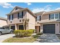 Exterior of the townhome featuring a well manicured yard, garages, and neutral paint at 2913 Ashford Park Pl, Oviedo, FL 32765