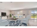 Bright living room with stylish furniture, a decorative rug, and sliding glass doors to the backyard at 3060 Water Clover Ct, Apopka, FL 32712