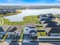 Aerial view of homes near a lake featuring lush green lawns, community sidewalks and white fences at 3070 Prelude Ln, Kissimmee, FL 34746