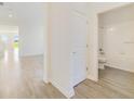 Bright hallway leading to a full bathroom, with tile floors, white walls, and plenty of natural light at 3070 Prelude Ln, Kissimmee, FL 34746