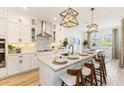 Spacious kitchen featuring white cabinets, stainless steel appliances, large center island with seating at 3235 Legends Preserve Dr, Daytona Beach, FL 32124