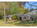 Charming single-story home featuring a well-manicured lawn, mature trees, and a welcoming entrance at 33639 Wesley Rd, Eustis, FL 32736