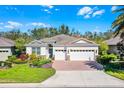 Beautiful single-Gathering home with a well-manicured lawn, a three-car garage, and a brick-paved driveway at 3618 Solana Cir, Clermont, FL 34711